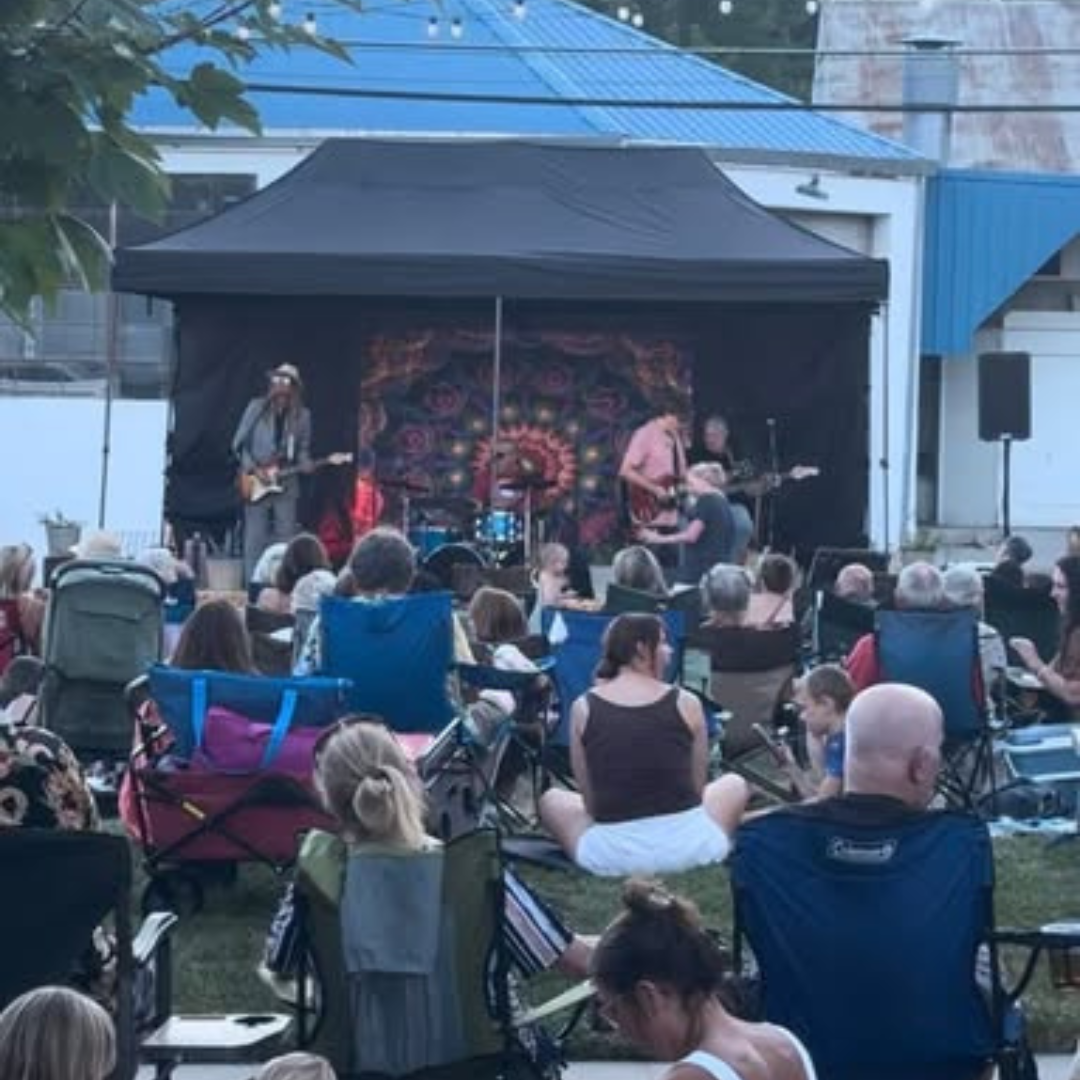 Evening set under the stage canopy with a seated crowd
