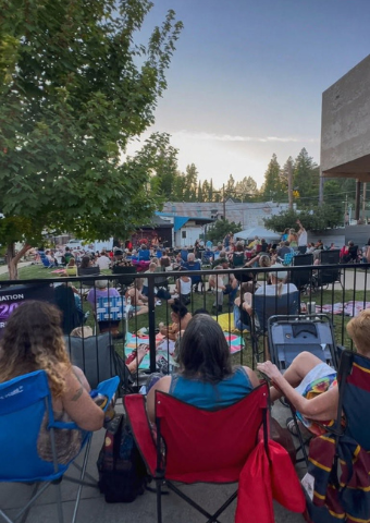 Crowd in lawn chairs watching a free concert in Colfax at dusk