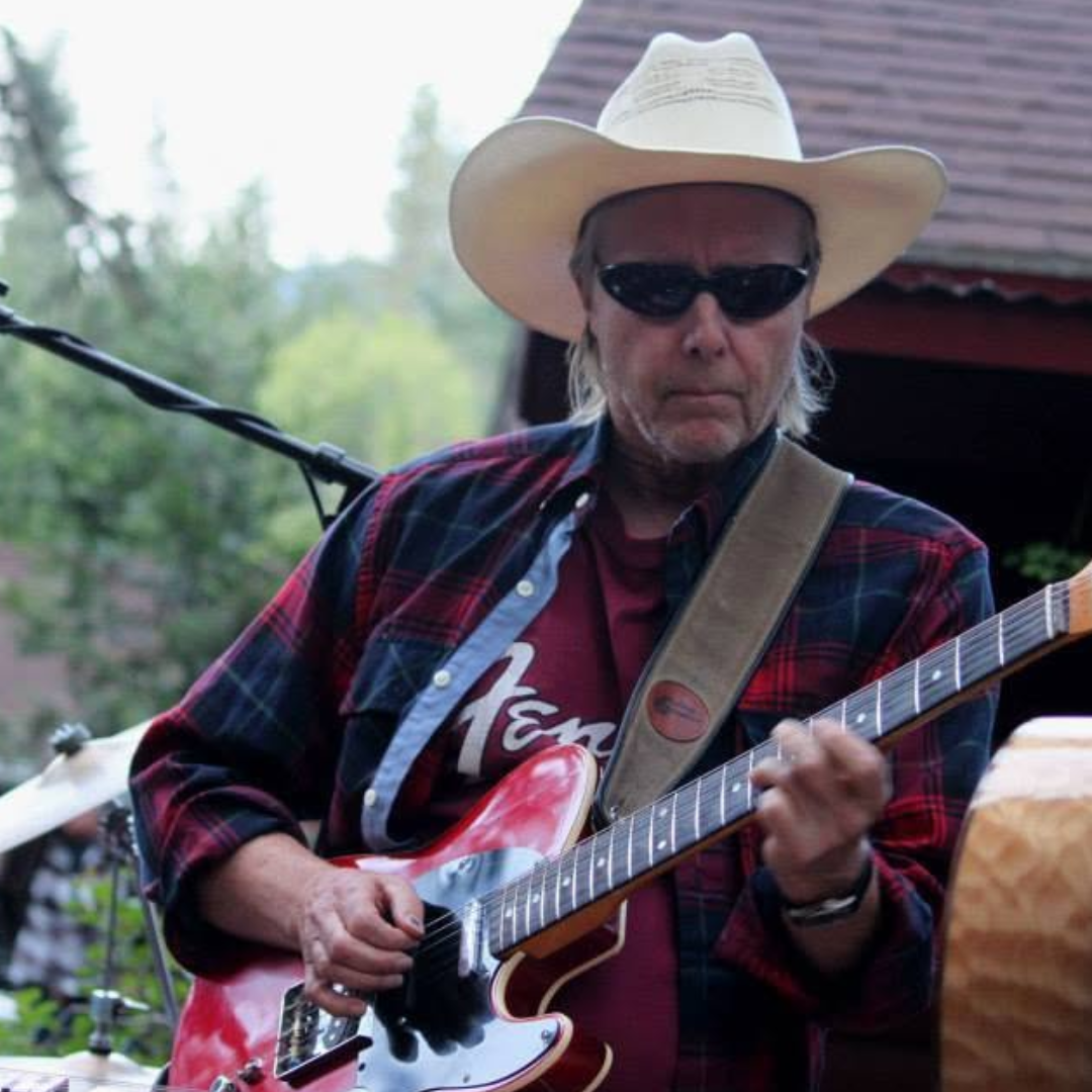 Guitarist in a cowboy hat playing a red Telecaster on stage